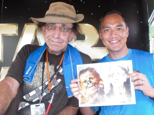 Peter Mayhew (Chewbacca), June 2013, at Disney's Hollywood Studios.  Notice his "shredded" T-shirt, ostensibly revealing Chewbacca's bandolier and Wookie fur.